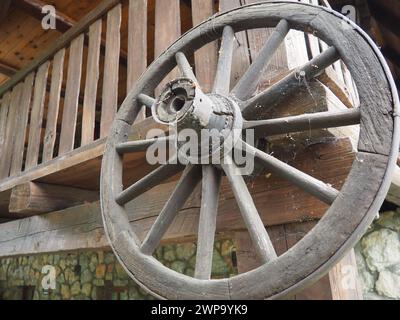 Une roue est un mobile, un disque qui tourne librement ou qui est fixé sur un axe rotatif, permettant au corps placé sur elle de rouler plutôt que de glisser. Roue en bois Banque D'Images