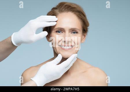 Chirurgie plastique, concept. Forme idéale du visage de femme pour la chirurgie plastique, visage de femme de référence sur fond bleu Banque D'Images
