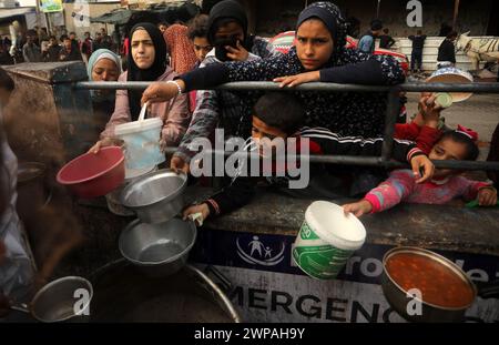 Rafah, Gaza. 06 mars 2024. Des enfants palestiniens attendent de recevoir de la nourriture préparée par une cuisine caritative dans un contexte de pénurie de vivres, à Rafah, dans le Sud de la bande de Gaza, mercredi 6 mars 2024. Les approvisionnements alimentaires, compte tenu de la poursuite du grave siège israélien, sont insuffisants dans la bande de Gaza. Photo de Ismael Mohamad/UPI crédit : UPI/Alamy Live News Banque D'Images