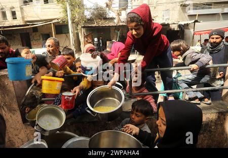 Rafah, Gaza. 06 mars 2024. Des enfants palestiniens attendent de recevoir de la nourriture préparée par une cuisine caritative dans un contexte de pénurie de vivres, à Rafah, dans le Sud de la bande de Gaza, mercredi 6 mars 2024. Les approvisionnements alimentaires, compte tenu de la poursuite du grave siège israélien, sont insuffisants dans la bande de Gaza. Photo de Ismael Mohamad/UPI crédit : UPI/Alamy Live News Banque D'Images