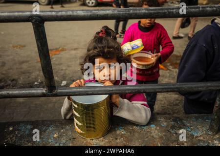 Rafah, Gaza. 06 mars 2024. Des enfants palestiniens attendent de recevoir de la nourriture préparée par une cuisine caritative dans un contexte de pénurie de vivres, à Rafah, dans le Sud de la bande de Gaza, mercredi 6 mars 2024. Les approvisionnements alimentaires, compte tenu de la poursuite du grave siège israélien, sont insuffisants dans la bande de Gaza. Photo de Ismael Mohamad/UPI crédit : UPI/Alamy Live News Banque D'Images