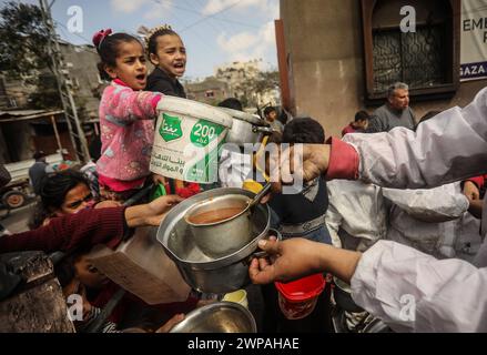 Rafah, Gaza. 06 mars 2024. Des enfants palestiniens attendent de recevoir de la nourriture préparée par une cuisine caritative dans un contexte de pénurie de vivres, à Rafah, dans le Sud de la bande de Gaza, mercredi 6 mars 2024. Les approvisionnements alimentaires, compte tenu de la poursuite du grave siège israélien, sont insuffisants dans la bande de Gaza. Photo de Ismael Mohamad/UPI crédit : UPI/Alamy Live News Banque D'Images