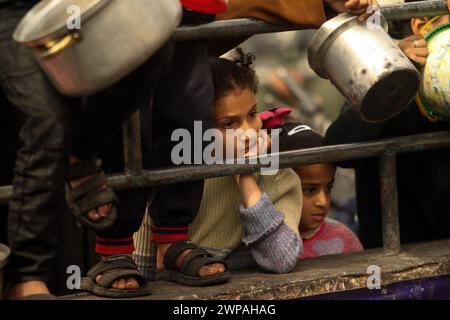 Rafah, Gaza. 06 mars 2024. Des enfants palestiniens attendent de recevoir de la nourriture préparée par une cuisine caritative dans un contexte de pénurie de vivres, à Rafah, dans le Sud de la bande de Gaza, mercredi 6 mars 2024. Les approvisionnements alimentaires, compte tenu de la poursuite du grave siège israélien, sont insuffisants dans la bande de Gaza. Photo de Ismael Mohamad/UPI crédit : UPI/Alamy Live News Banque D'Images