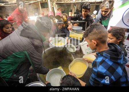 Rafah, Gaza. 06 mars 2024. Des enfants palestiniens attendent de recevoir de la nourriture préparée par une cuisine caritative dans un contexte de pénurie de vivres, à Rafah, dans le Sud de la bande de Gaza, mercredi 6 mars 2024. Les approvisionnements alimentaires, compte tenu de la poursuite du grave siège israélien, sont insuffisants dans la bande de Gaza. Photo de Ismael Mohamad/UPI crédit : UPI/Alamy Live News Banque D'Images