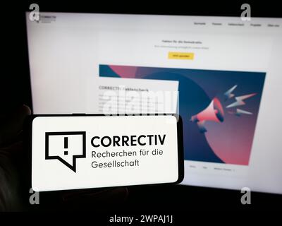 Personne tenant un smartphone avec le logo de Correctiv - Recherchen für die Gesellschaft gGmbH en face du site. Concentrez-vous sur l'affichage du téléphone. Banque D'Images