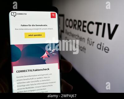 Personne tenant le téléphone portable avec la page web de Correctiv - Recherchen für die Gesellschaft gGmbH devant le logo. Concentrez-vous sur le centre de l'écran du téléphone. Banque D'Images