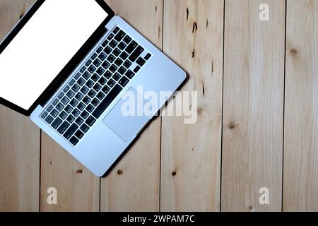 Gros plan ordinateur portable portable ouvert sur l'écran blanc blanc mis sur la table en bois pour le travail, le divertissement, les médias sociaux et les achats en ligne Banque D'Images