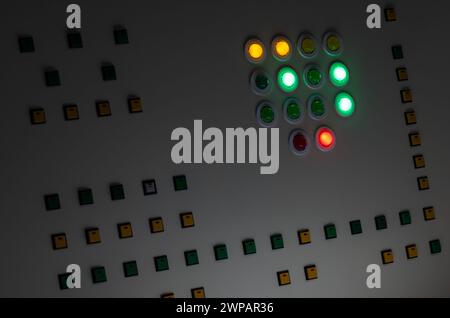 Panneau de commande industriel avec boutons lumineux brillants avec différentes couleurs dans l'obscurité Banque D'Images