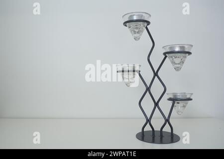 Grand lustre moderne en métal avec supports en verre pour petites bougies dans un emballage en aluminium. Placer pour le texte. Fond blanc. Copier l'espace Banque D'Images