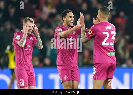 Ben Cabango de Swansea City (au centre) et Nathan Wood (à droite) célèbrent le premier but de leur équipe du match, marqué par Ryan Andrews de Watford (non représenté) via un but lors du match du Sky Bet Championship à Vicarage Road, Watford. Date de la photo : mercredi 6 mars 2024. Banque D'Images