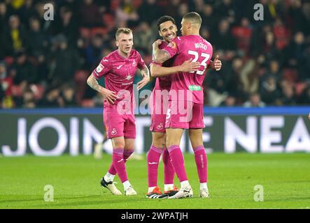 Ben Cabango de Swansea City et Nathan Wood (à droite) célèbrent le premier but de leur équipe du match, marqué par Ryan Andrews de Watford (non représenté) via un but lors du Sky Bet Championship match à Vicarage Road, Watford. Date de la photo : mercredi 6 mars 2024. Banque D'Images