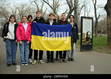 Les jeunes patriotes tiennent le drapeau de l'Ukraine sur fond d'une affiche d'information avec l'image de Taras Shevchenkoin dans le Parc central de la culture et des loisirs nommé d'après Taras Grigorievich Shevchenko. De jeunes patriotes organisent un événement dédié à l’anniversaire du célèbre poète ukrainien. Taras Hryhorovych Chevtchenko (9 mars 1814 - 10 mars 1861) est un poète, écrivain, artiste, personnalité politique, folkloriste et ethnographe ukrainien. Il est membre de l'Académie impériale des Arts et membre de la Fraternité des Saints Cyrille et méthode. (Photo de Viacheslav Onyshchenko/SOPA I Banque D'Images