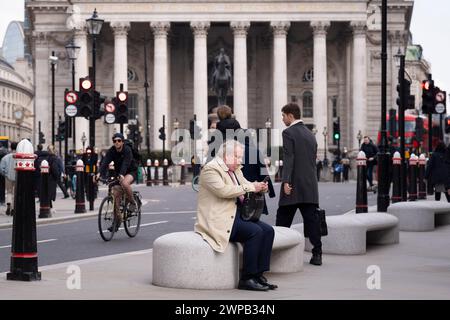 Un homme d'affaires fait une pause devant le Royal Exchange dans la City de Londres, le quartier financier de la capitale, le 6 mars 2024, à Londres, en Angleterre. Banque D'Images