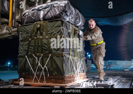 Azraq, Jordanie. 05 mars 2024. Des soldats de l'armée américaine et des aviateurs de l'armée de l'air chargent des palettes d'aide humanitaire dans la soute d'un avion C-130J Super Hercules de l'armée de l'air américaine à la base aérienne de Muwaffaq Salti, le 5 mars 2024 à Azraq, gouvernorat de Zarqa, Jordanie. L’aide alimentaire sera larguée par voie aérienne aux réfugiés palestiniens pris au piège de la guerre israélienne contre le Hamas. Crédit : SRA Lauren Jacoby/US Airforce photo/Alamy Live News Banque D'Images