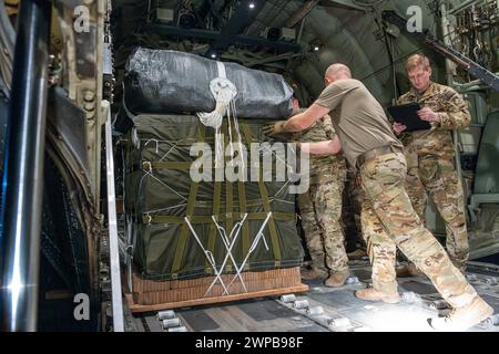 Azraq, Jordanie. 05 mars 2024. Des soldats de l'armée américaine et des aviateurs de l'armée de l'air chargent des palettes d'aide humanitaire dans la soute d'un avion C-130J Super Hercules de l'armée de l'air américaine à la base aérienne de Muwaffaq Salti, le 5 mars 2024 à Azraq, gouvernorat de Zarqa, Jordanie. L’aide alimentaire sera larguée par voie aérienne aux réfugiés palestiniens pris au piège de la guerre israélienne contre le Hamas. Crédit : SRA Lauren Jacoby/US Airforce photo/Alamy Live News Banque D'Images