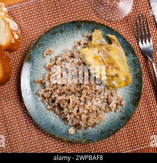 Sarrasin bouilli dans un bol avec cuisses de poulet. Table de dîner, concept de nourriture saine Banque D'Images