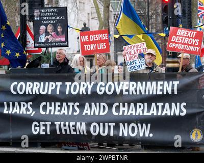 Les manifestants brandissent des banderoles et des pancartes avec des slogans anti-conservateurs et anti-Brexit devant le Parlement de Westminster à Londres le jour du budget 6 mars 2024 Banque D'Images