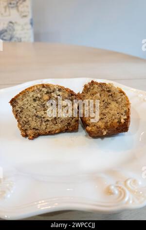 Muffin à la banane fait maison coupé en deux sur une assiette blanche. ÉTATS-UNIS. Banque D'Images