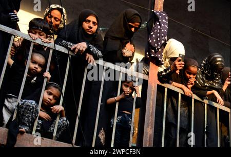 Femmes chiites regardant vers le bas la procession religieuse autour de la mosquée iranienne ( Mughal Masjid ) pendant le mois sacré de Mouharram. Mumbai, Inde. Banque D'Images