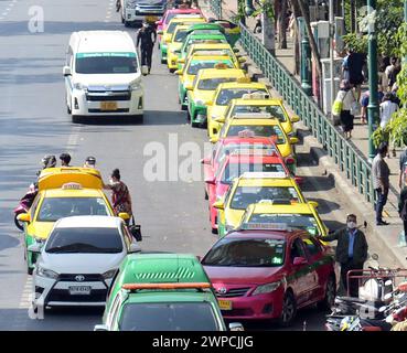 Une longue file de taxis thaïlandais colorés attend devant le marché Chatuchak à Bangkok, en Thaïlande. Banque D'Images