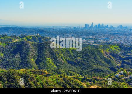 Perspective aérienne capturant l'emblématique observatoire Griffith niché dans les collines, avec la ville tentaculaire de Los Angeles s'étendant à l'horizon. Banque D'Images