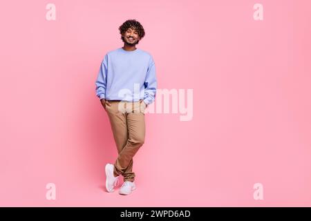 Photo en taille réelle de jeune homme gentil posant des poches de mains de modèle habillé élégant costume bleu isolé sur fond de couleur rose Banque D'Images