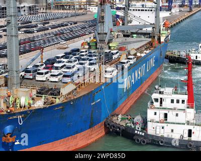 YANTAI, CHINE - 6 MARS 2024 - les cargos accostent pour charger des véhicules destinés à l'exportation au port de Yantai, dans la province du Shandong, dans l'est de la Chine, le 6 mars 2024. O Banque D'Images