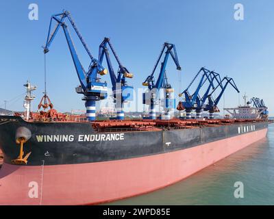 YANTAI, CHINE - 6 MARS 2024 - les cargos déchargent de la bauxite dans le port de Yantai, dans la province du Shandong de l'est de la Chine, le 6 mars 2024. Le 7 mars 2024, dat Banque D'Images