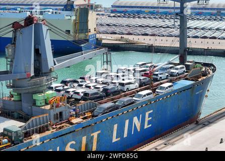 YANTAI, CHINE - 6 MARS 2024 - les cargos chargent des wagons destinés à l'exportation au port de Yantai, dans la province du Shandong de l'est de la Chine, le 6 mars 2024. Le 7 mars 202 Banque D'Images