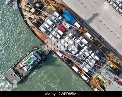 YANTAI, CHINE - 6 MARS 2024 - les cargos accostent pour charger des véhicules destinés à l'exportation au port de Yantai, dans la province du Shandong, dans l'est de la Chine, le 6 mars 2024. O Banque D'Images