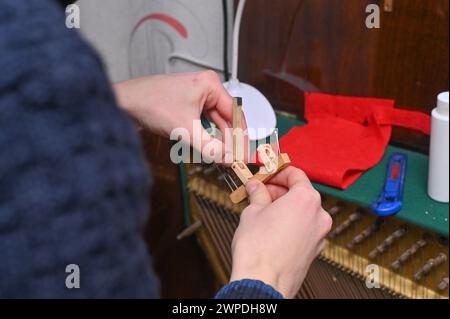 Le marteau de piano est entre les mains de l'accordeur. réparation du marteau de piano. Banque D'Images