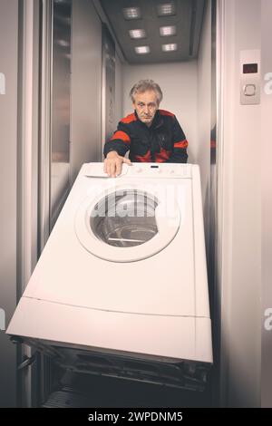 Homme plus âgé dans la machine de lavage en mouvement global sur chariot avec ascenseur Banque D'Images