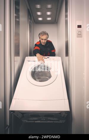 Homme plus âgé dans la machine de lavage en mouvement global sur chariot avec ascenseur Banque D'Images