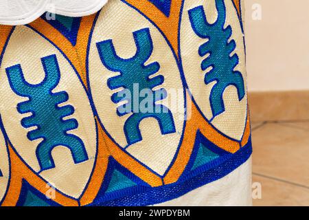Vue rapprochée d'un design textile africain dynamique avec broderies complexes et motifs géométriques audacieux, mettant en valeur le riche patrimoine culturel et Banque D'Images