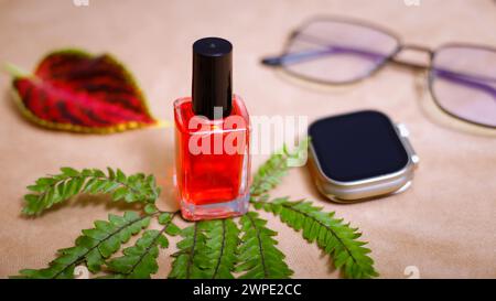 Closup de montre intelligente élégante, vernis à ongles et verre de soleil. Dans le tableau fond marron. Réflexion de la lumière Banque D'Images