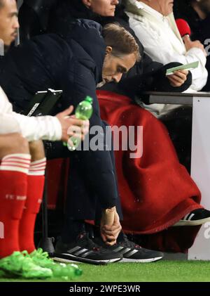 Entraîneur Thomas Tuchel du Bayern Muenchen behandelt sich mit Vereisungsspray seinen verletzten Fuss entraîneur Thomas Tuchel FC Bayern Munich ices son orteil à travers sa chaussure avec un spray glacant Tuchel avait endommagé son orteil lors de son discours émotionnel avant le match MUNICH, ALLEMAGNE - MARS 05: UEFA Champions League 2023/24 manche du 16e match de deuxième manche entre le FC Bayern MŸnchen et le SS Lazio à l'Allianz Arena le 05 mars 2024 à Munich © diebilderwelt / Alamy Stock Banque D'Images