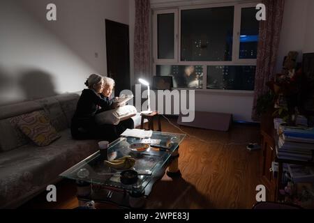 (240307) -- HARBIN, 7 mars 2024 (Xinhua) -- Jiang Shumei (à droite) vérifie une traite avec sa fille Zhang en train de souffrir chez elle dans le district de Beilin de la ville de Suihua, province du Heilongjiang, au nord-est de la Chine, le 5 mars 2024. Jiang Shumei, 87 ans, une grand-mère analphabète qui a appris à lire à l’âge de 60 ans, a peint plus de 300 peintures et publié 6 livres, réalisant une transformation étonnante dans ses années crépusculaires. Né dans le comté de Juye de la province chinoise du Shandong en 1937, Jiang vit actuellement dans la ville de Suihua de la province chinoise du Heilongjiang. En 1996, le mari de Jiang meurt dans un accident de la route. Afin de ré Banque D'Images