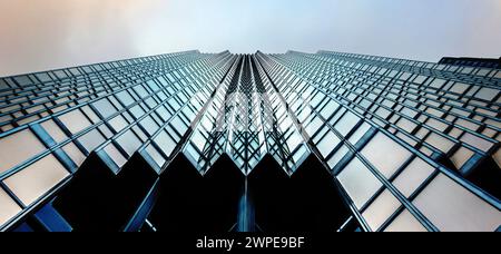 Vue de dessous du gratte-ciel bleu dans le quartier des affaires. Levant les yeux face à un ciel coloré Banque D'Images
