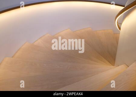 Escaliers en bois menant vers le bas avec des mains courantes éclairées Banque D'Images