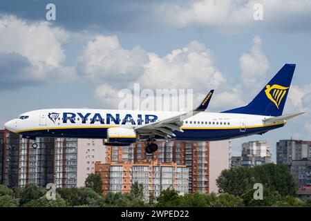 Le Boeing 737-800 Ryanair de la compagnie aérienne irlandaise low-cost atterrissant à l'aéroport de Lviv avec la ville en arrière-plan Banque D'Images