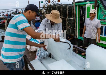 Ouvrier avec des blocs de glace au marché aux poissons de Hoi an Banque D'Images