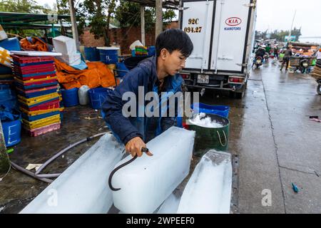 Ouvrier avec des blocs de glace au marché aux poissons de Hoi an Banque D'Images