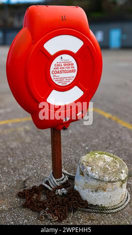 LifeBuoy Rescue Housing en rouge avec les coordonnées des garde-côtes en cas d'urgence afin de sauver des vies Banque D'Images