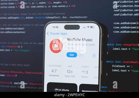 New York, États-Unis - 23 février 2024 : musique YouTube sur l'écran de l'iphone en arrière-plan de programmation de code flou Banque D'Images