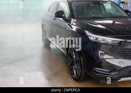 Lavage de voiture manuel avec eau sous pression dans le lavage de voiture extérieur Banque D'Images