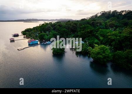 Spectaculaire vue aérienne matinale de l'île de San Cristobal dans l'archipel de bocas del toro dans la mer des Caraïbes, couverte de forêt et de petites maisons, panama Banque D'Images