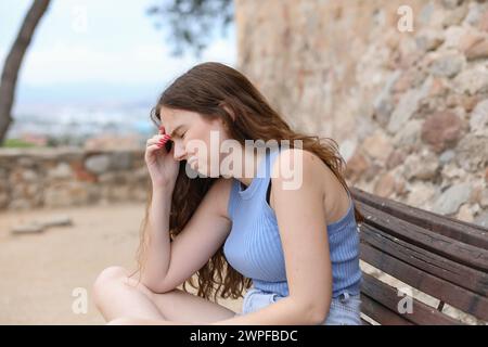 Femme seule et triste assise sur un banc Banque D'Images