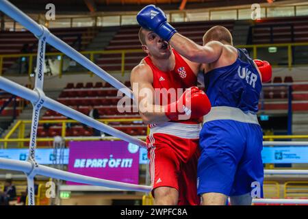 Busto Arsizio, Italie. 06 mars 2024. Luka Pratljacic (Rouge) de Croatie en action contre Dmytro Lovchynskyi (Bleu) d'Ukraine lors du 1er tournoi de qualification mondial Boxing Road to Paris combat entre Luka Pratljacic (Rouge) de Croatie et Dmytro Lovchynskyi (Bleu) d'Ukraine à E-Work Arena. (Photo de Fabrizio Carabelli/SOPA images/Sipa USA) crédit : Sipa USA/Alamy Live News Banque D'Images