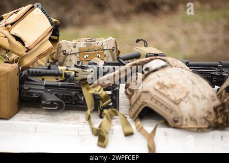 Arme de réplique Airsoft et casque de camouflage supérieur AOR 1, mitrailleuse sur un fond naturel Banque D'Images