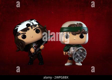 Funko figurines POP vinyle d'Eddie Munson et Dustin Henderson personnages de la série télévisée Stranger Things sur fond rouge. Éditorial illustratif o Banque D'Images